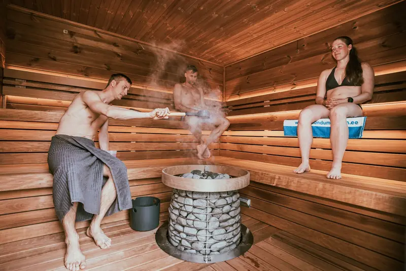 Three people enjoying a steamy sauna session, embracing wellness and relaxation