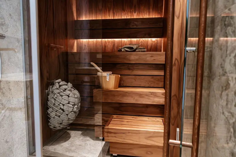 Discover the elegance of a modern indoor sauna featuring sleek wood panels and a glass door